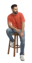 Photo of Handsome young man sitting on stool against white background