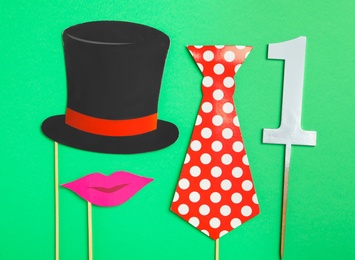 Photo of Flat lay composition with clown's accessories on green background