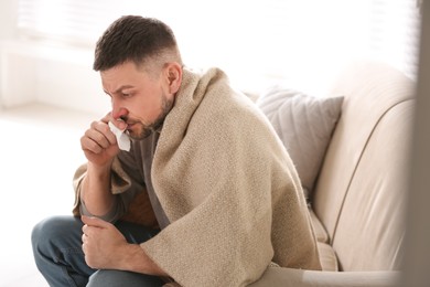 Photo of Man suffering from runny nose at home