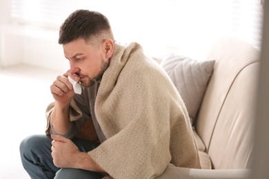 Man suffering from runny nose at home