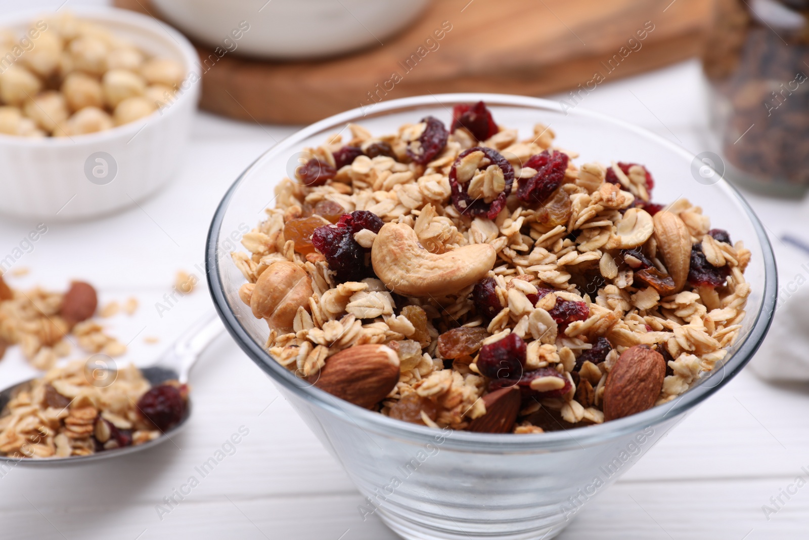 Photo of Bowl of tasty granola on white wooden table