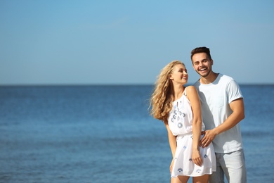 Photo of Happy young couple at beach on sunny day