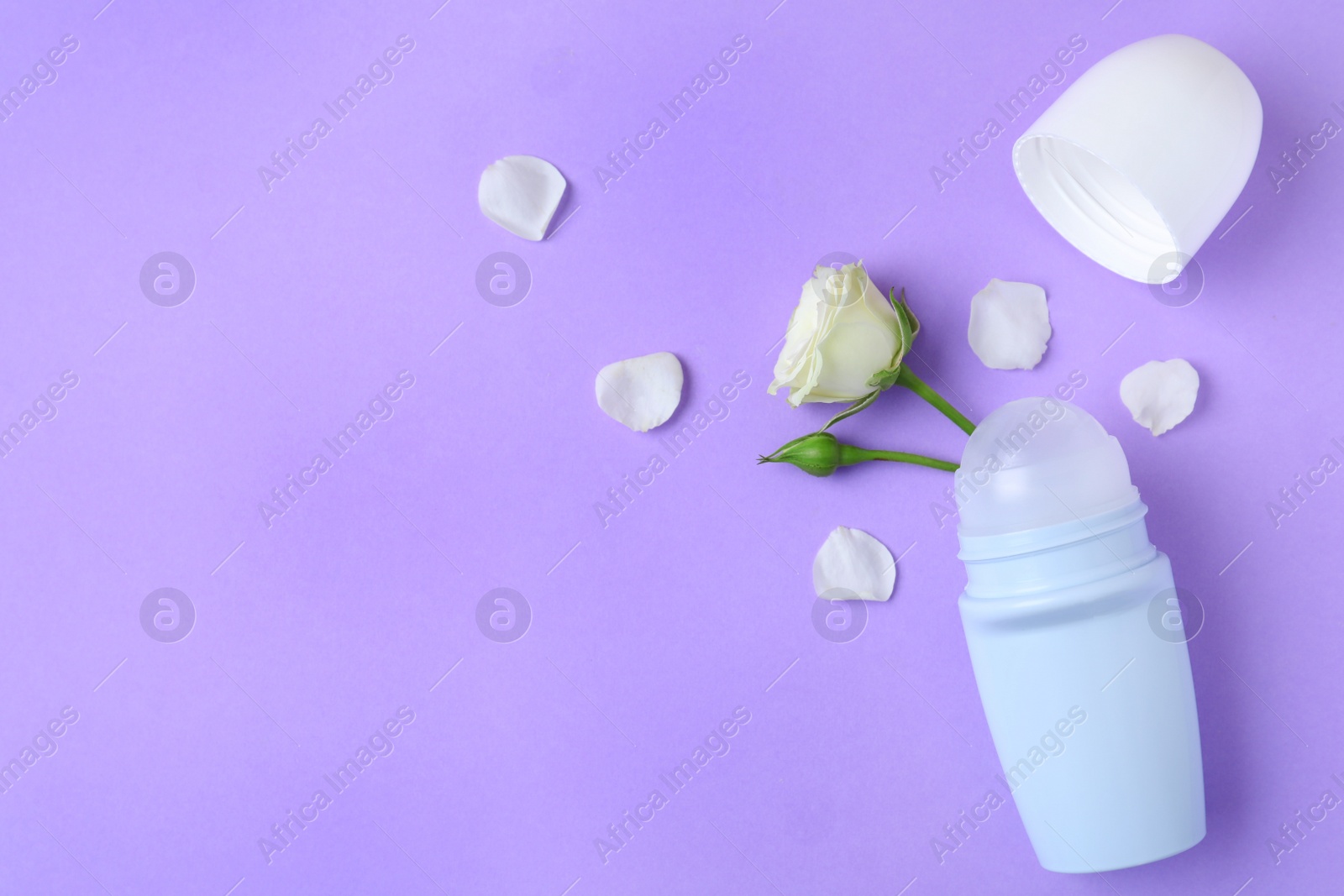 Photo of Flat lay composition with natural female roll-on deodorant on purple background, space for text