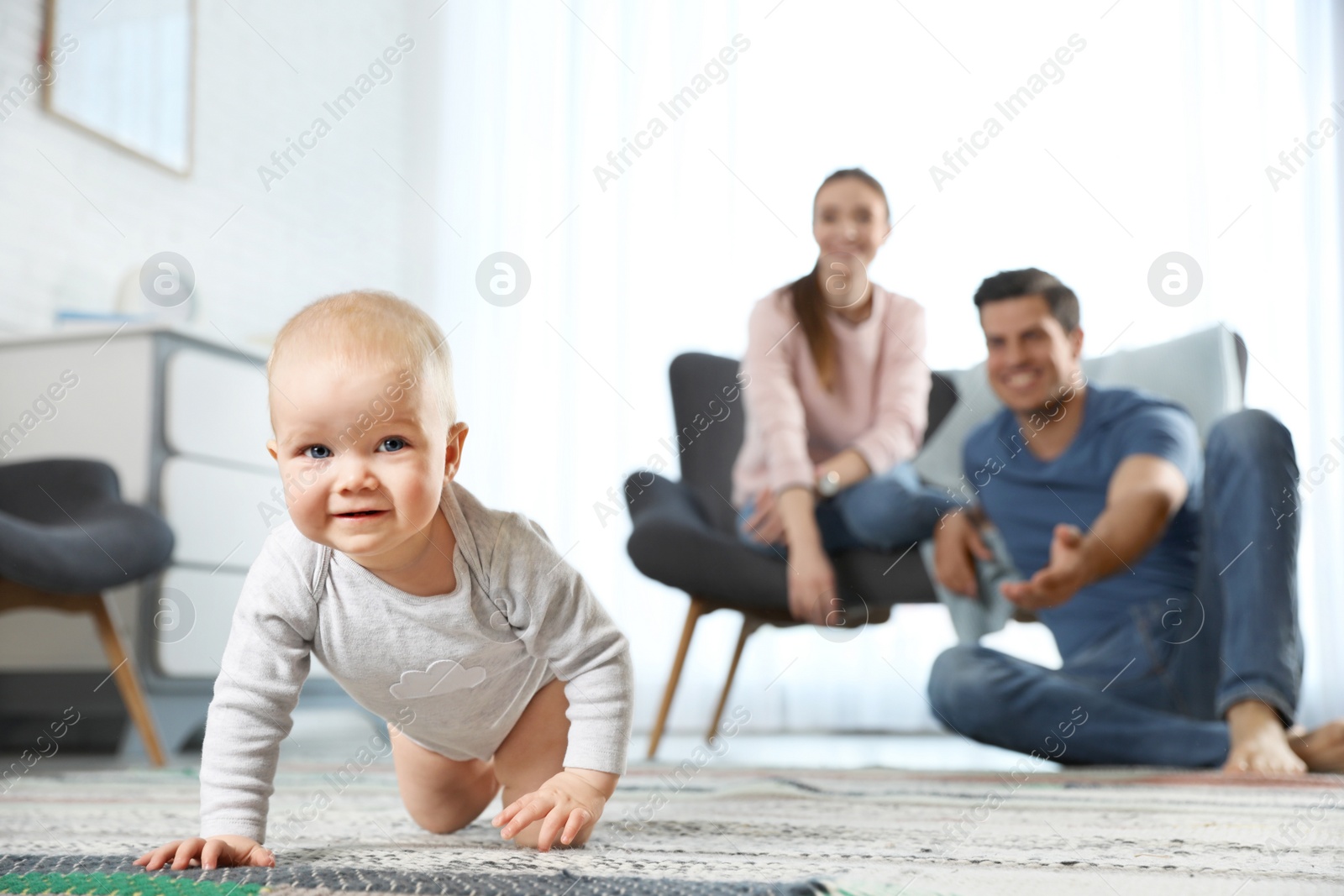 Photo of Adorable little baby crawling near parents at home