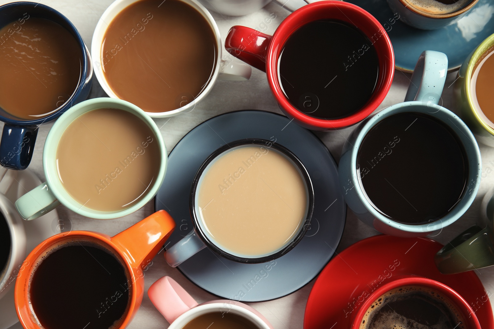 Photo of Cups of fresh aromatic coffee on light background, top view. Food photography