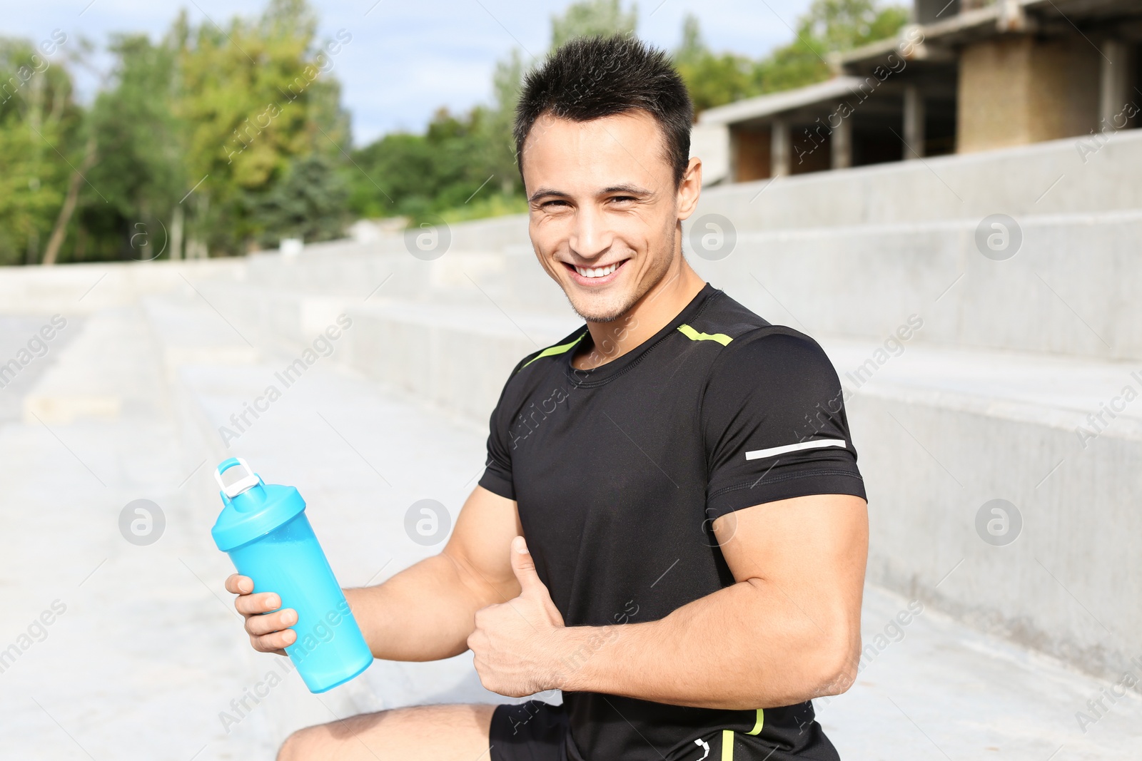 Photo of Man with bottle of protein shake on street