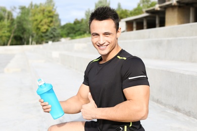 Man with bottle of protein shake on street