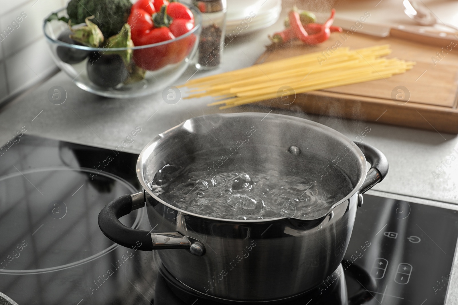 Photo of Pot with boiling water on electric stove in kitchen