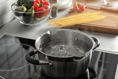 Pot with boiling water on electric stove in kitchen