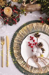 Christmas place setting for festive dinner on white table, flat lay. Bokeh effect