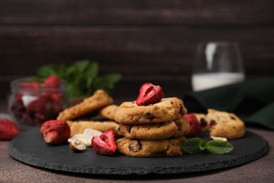 Photo of Cookies with freeze dried fruits, mint and nuts on grey table, closeup