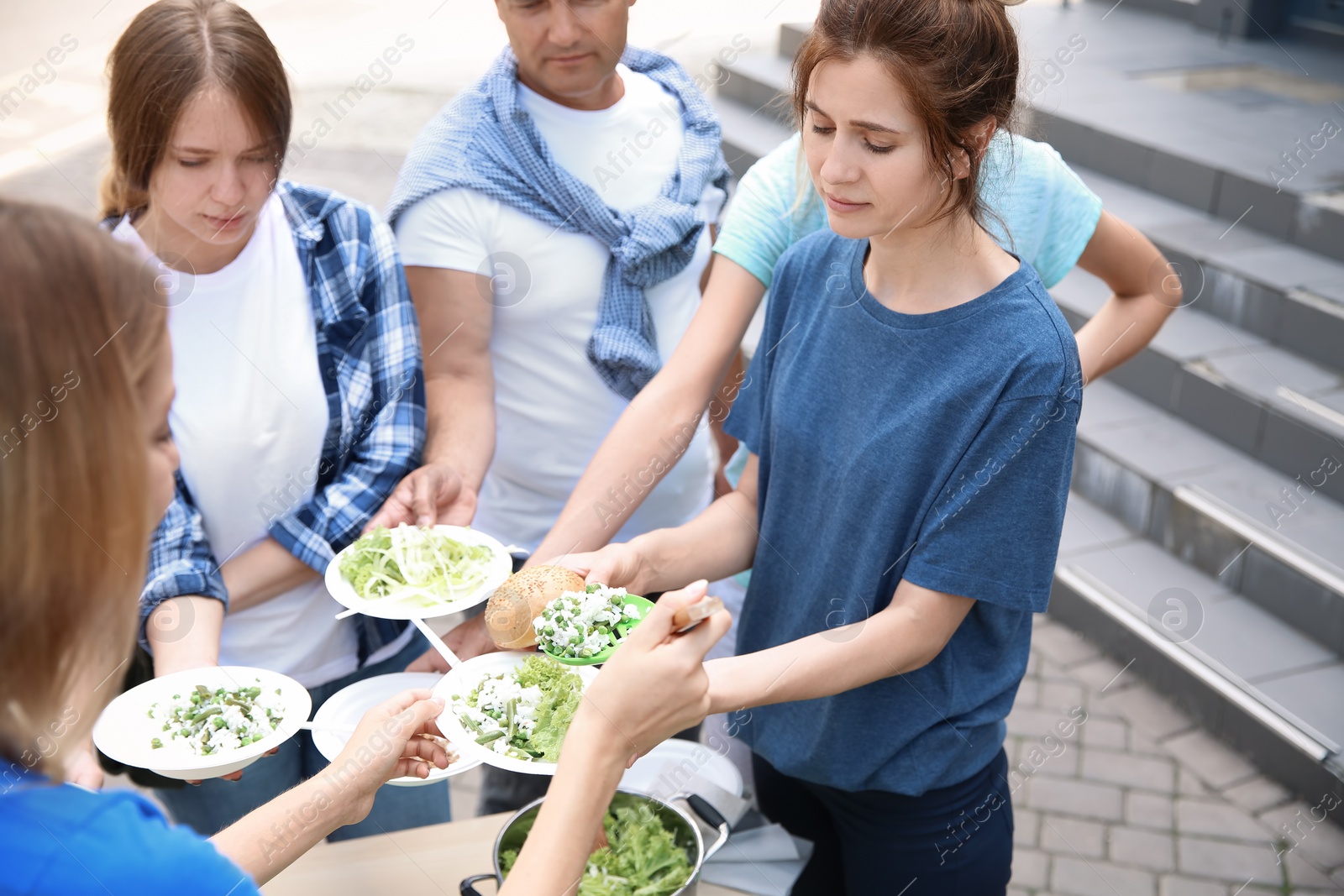 Photo of Volunteers serving food for poor people outdoors