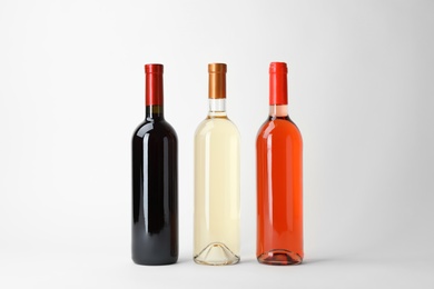 Photo of Bottles of expensive wines on light background