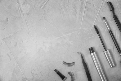 Flat lay composition with false eyelashes and cosmetic tools on grey background