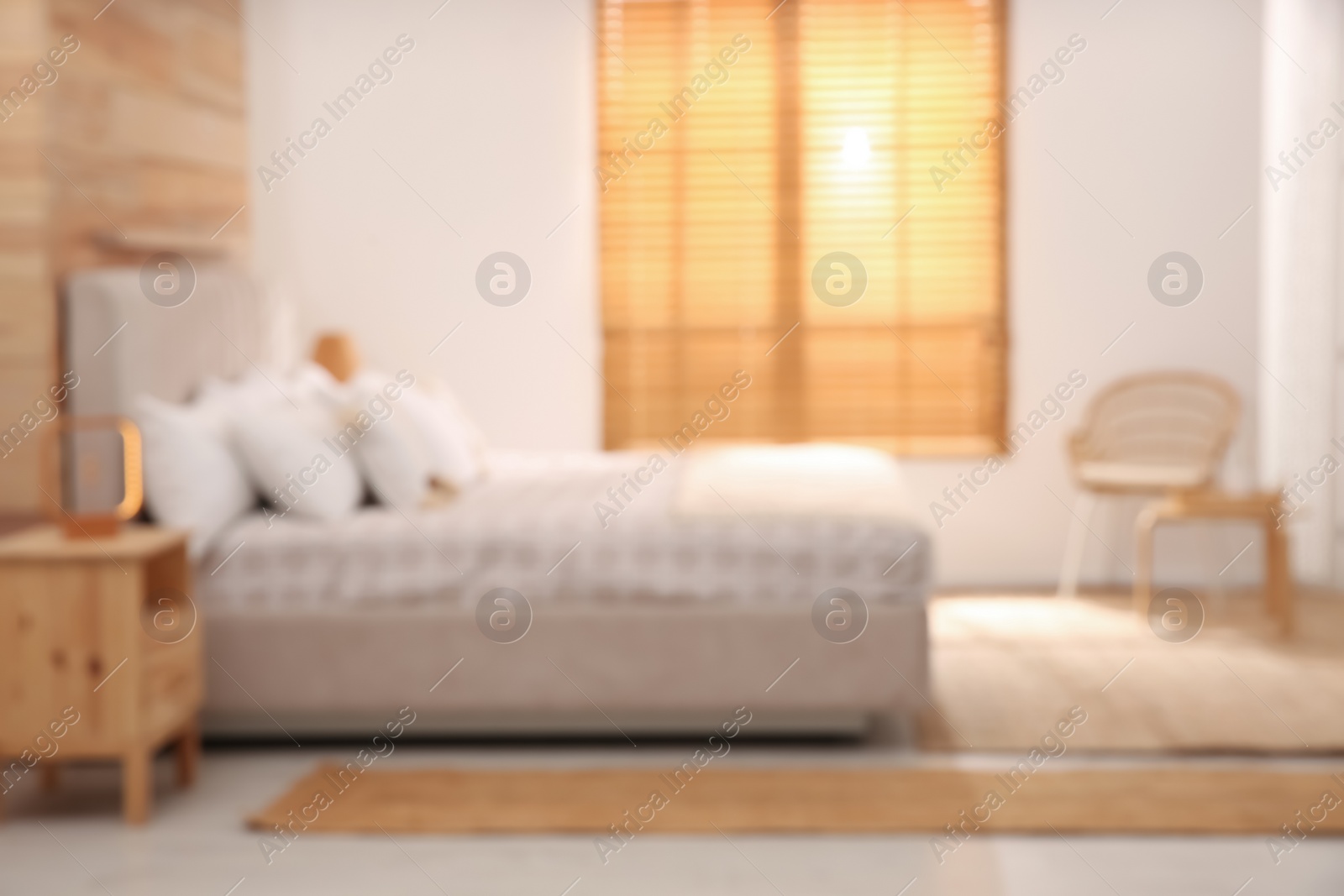 Photo of Blurred view of stylish hotel room interior with comfortable bed