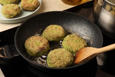 Photo of Cooking vegan cutlets in frying pan on stove, closeup