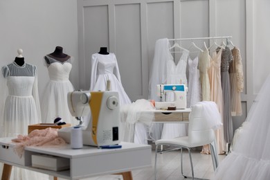Dressmaking workshop interior with wedding dresses and equipment