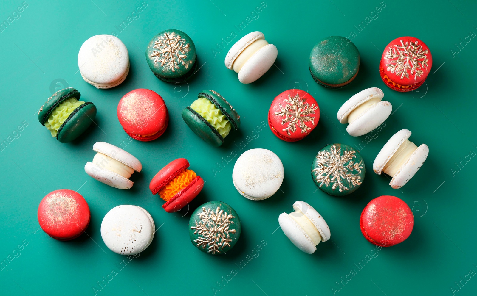 Photo of Beautifully decorated Christmas macarons on green background, flat lay