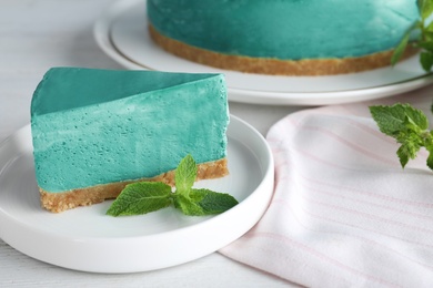 Photo of Delicious homemade spirulina cheesecake served on white wooden table