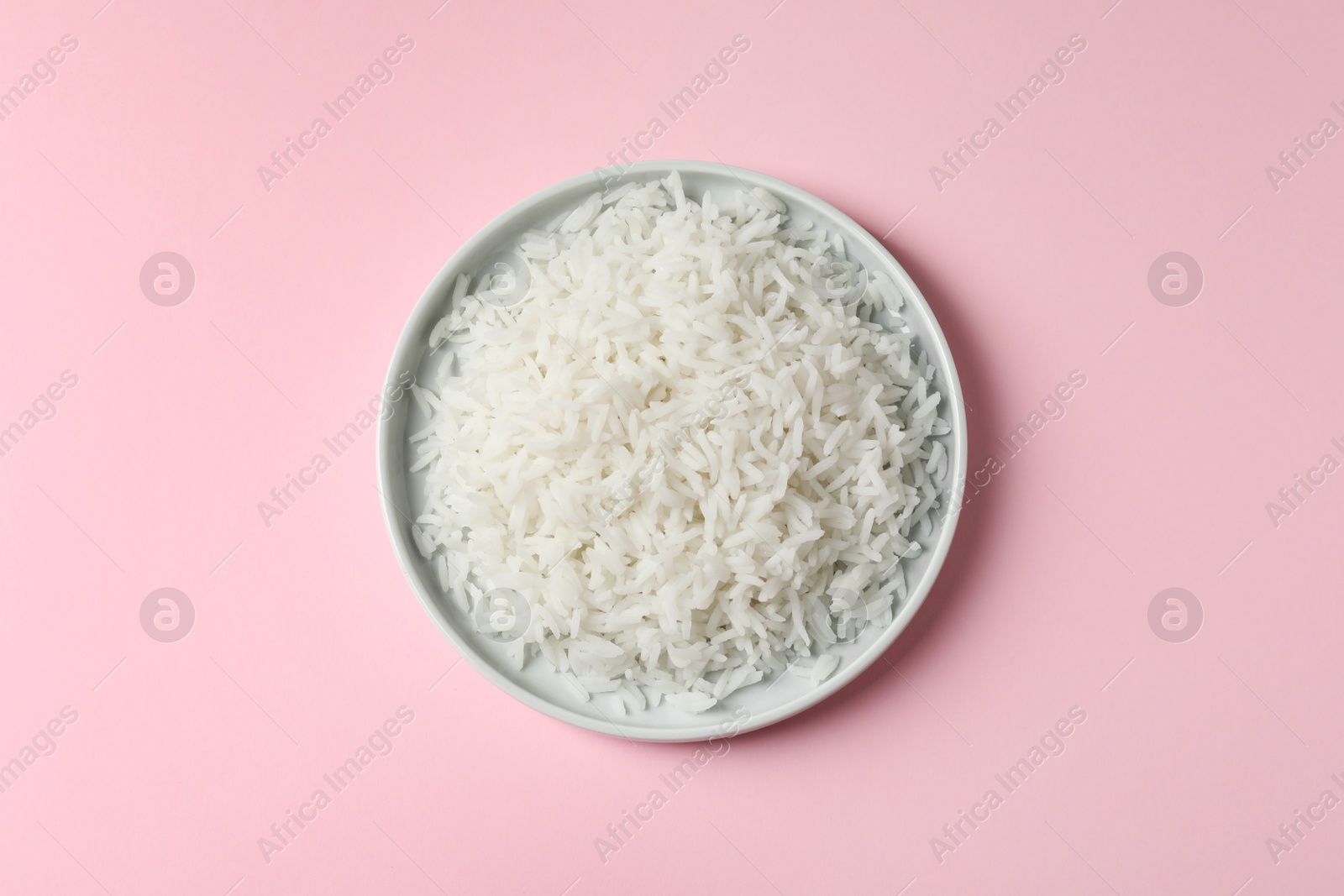 Photo of Plate of tasty cooked rice on color background, top view