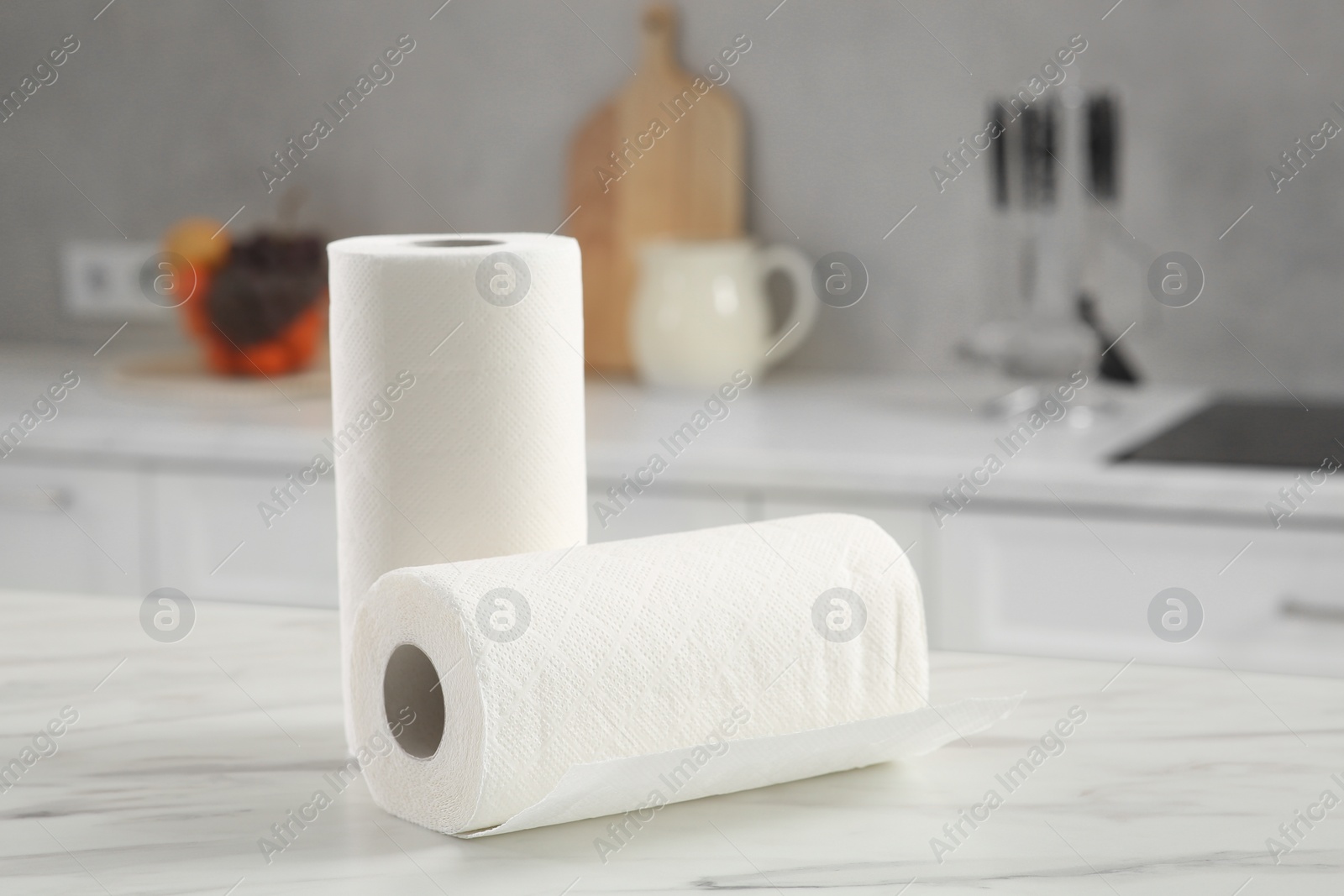 Photo of Rolls of paper towels on white marble table in kitchen