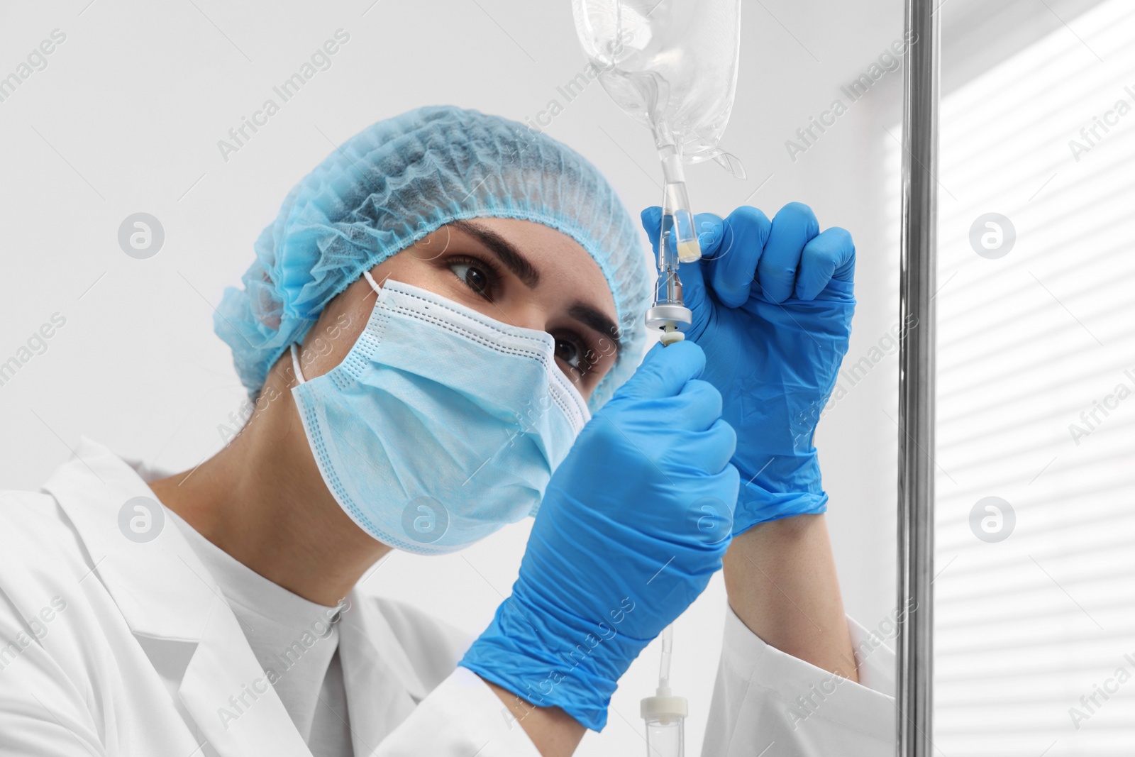 Photo of Nurse setting up IV drip in hospital