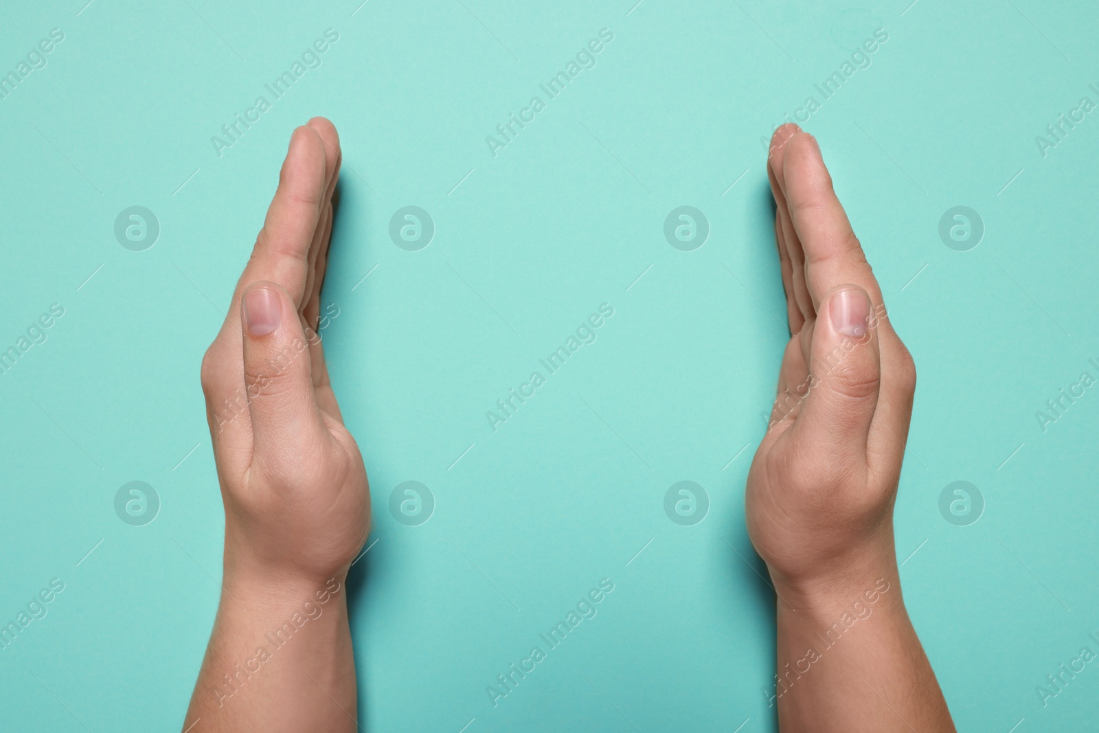 Photo of Woman holding on turquoise background, closeup of hands. Space for text