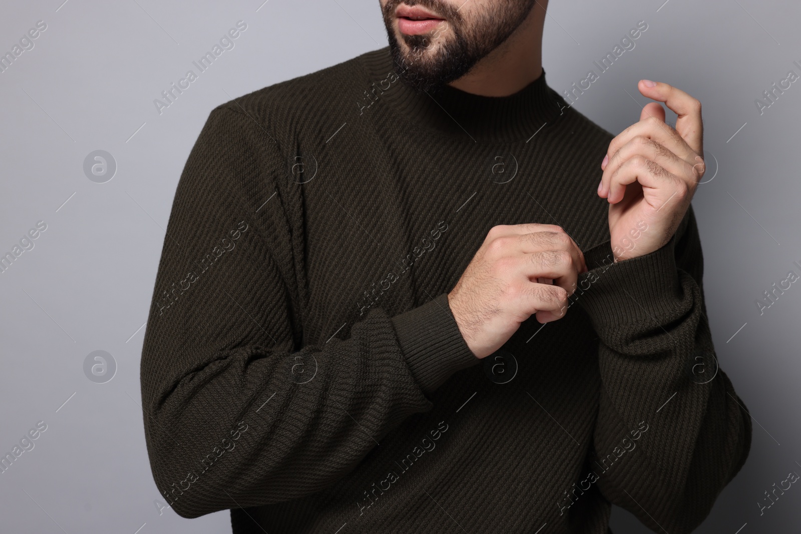 Photo of Man in stylish sweater on grey background, closeup