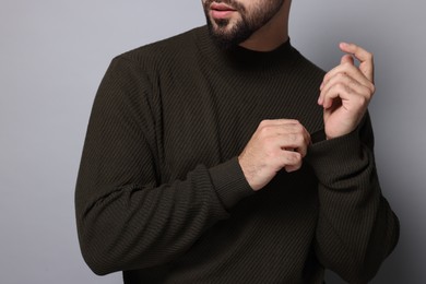 Man in stylish sweater on grey background, closeup