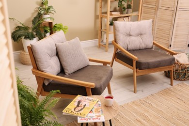 Lounge area interior with comfortable armchairs and beautiful houseplants