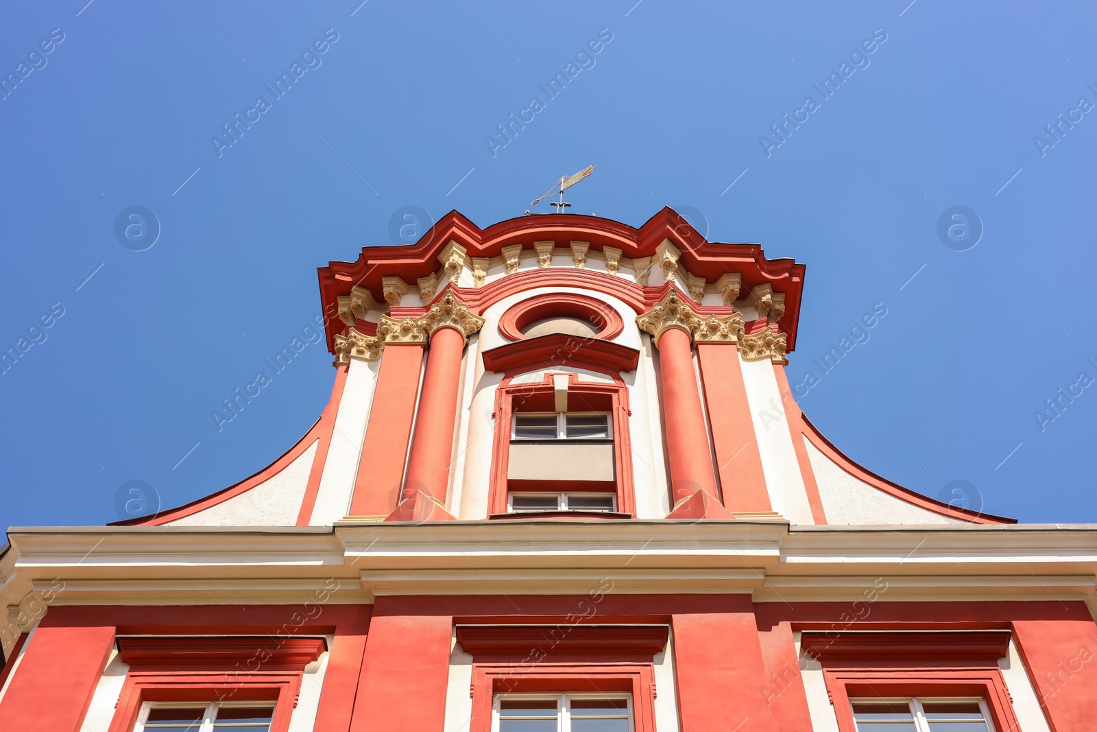 Photo of Beautiful building with weather vane on roof against blue sky, low angle view
