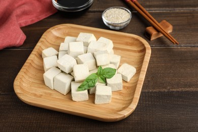Photo of Delicious tofu with basil served on wooden table