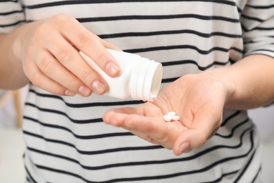 Photo of Young woman with bottle of pills, closeup