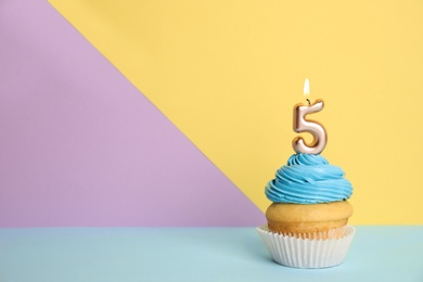 Photo of Birthday cupcake with number five candle on color background, space for text