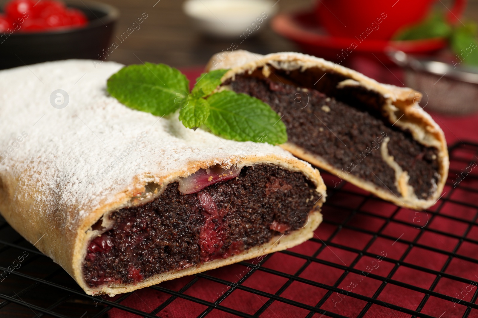 Photo of Delicious strudel with cherries and poppy seeds on table, closeup