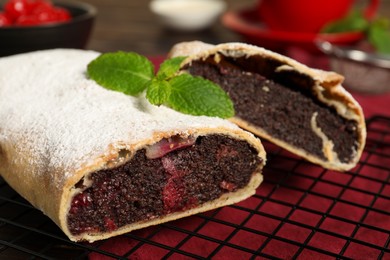 Delicious strudel with cherries and poppy seeds on table, closeup