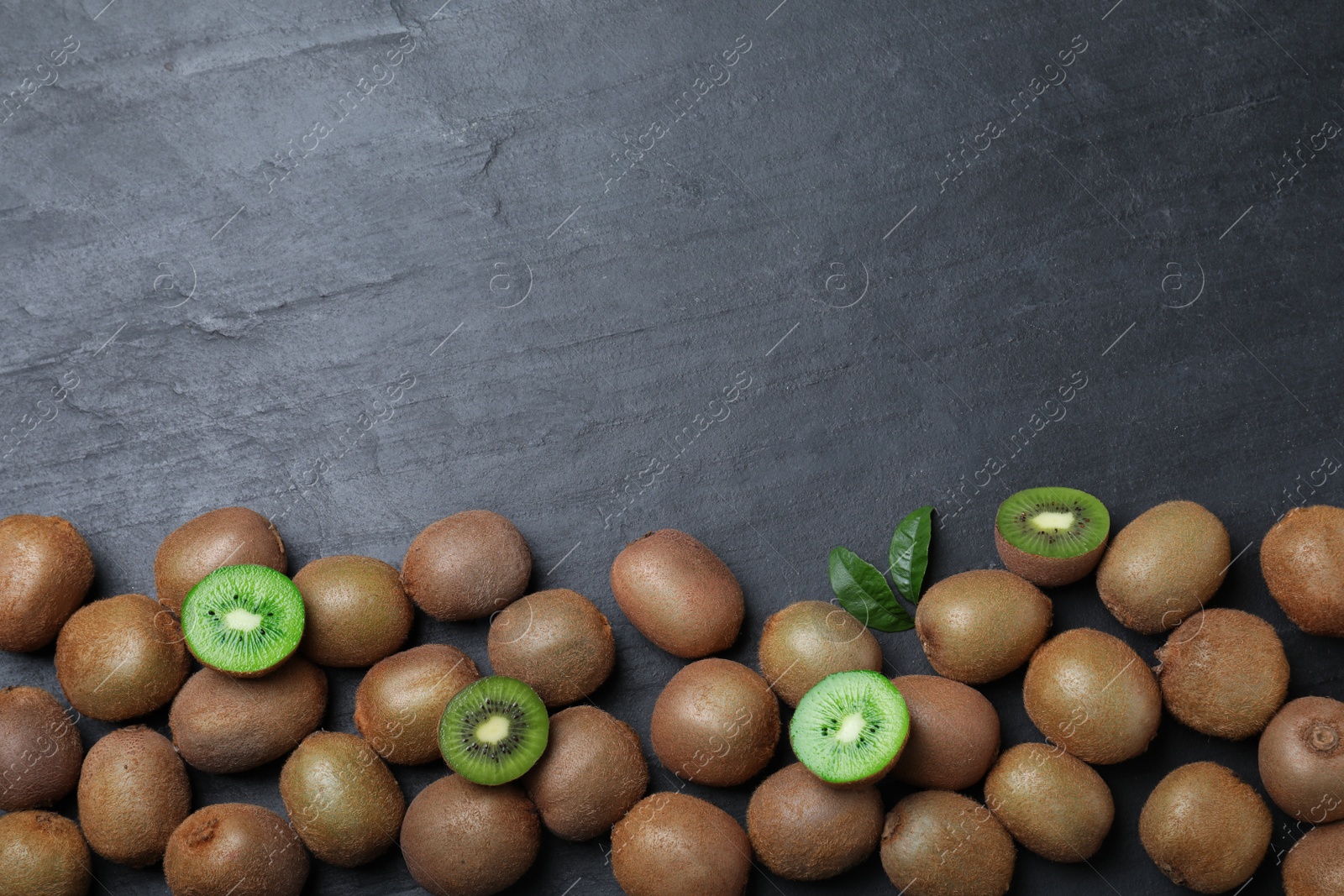 Photo of Fresh ripe kiwis on black table, flat lay. Space for text