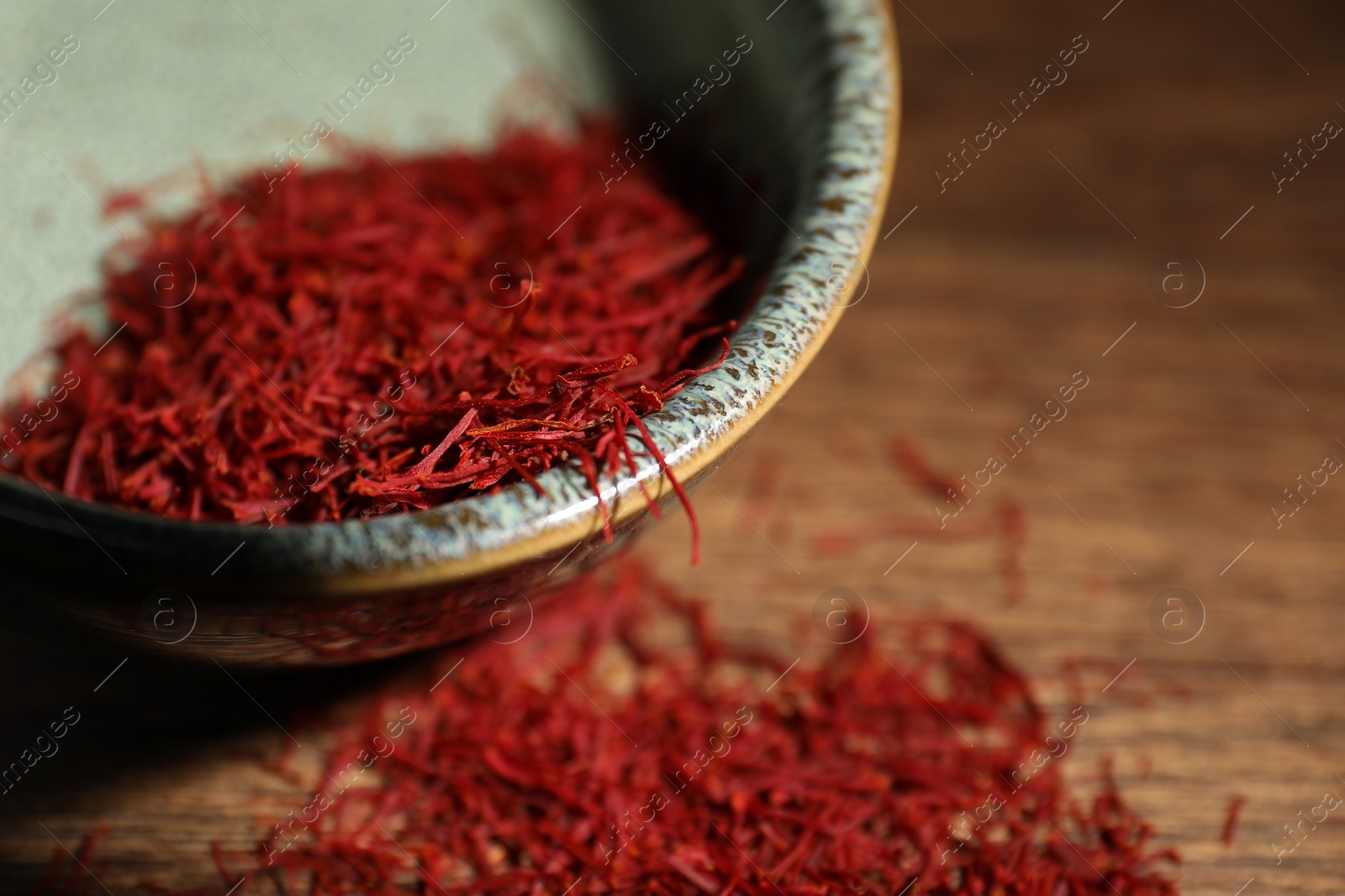 Photo of Aromatic saffron in bowl on table, closeup