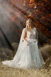 Beautiful girl wearing fairy dress in autumn forest