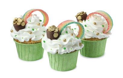 Photo of St. Patrick's day party. Tasty cupcakes with sour rainbow belt and pot of gold toppers isolated on white