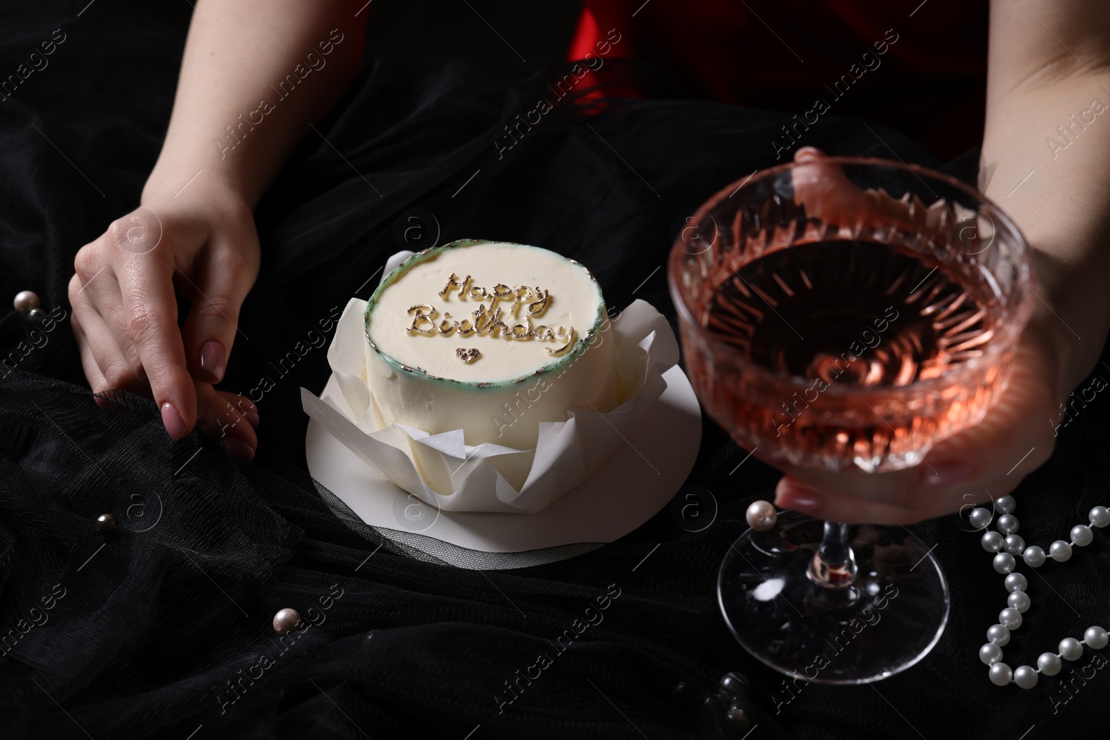 Photo of Fashionable photo of woman with her Birthday cake and glass of wine on black background, closeup