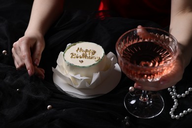 Photo of Fashionable photo of woman with her Birthday cake and glass of wine on black background, closeup