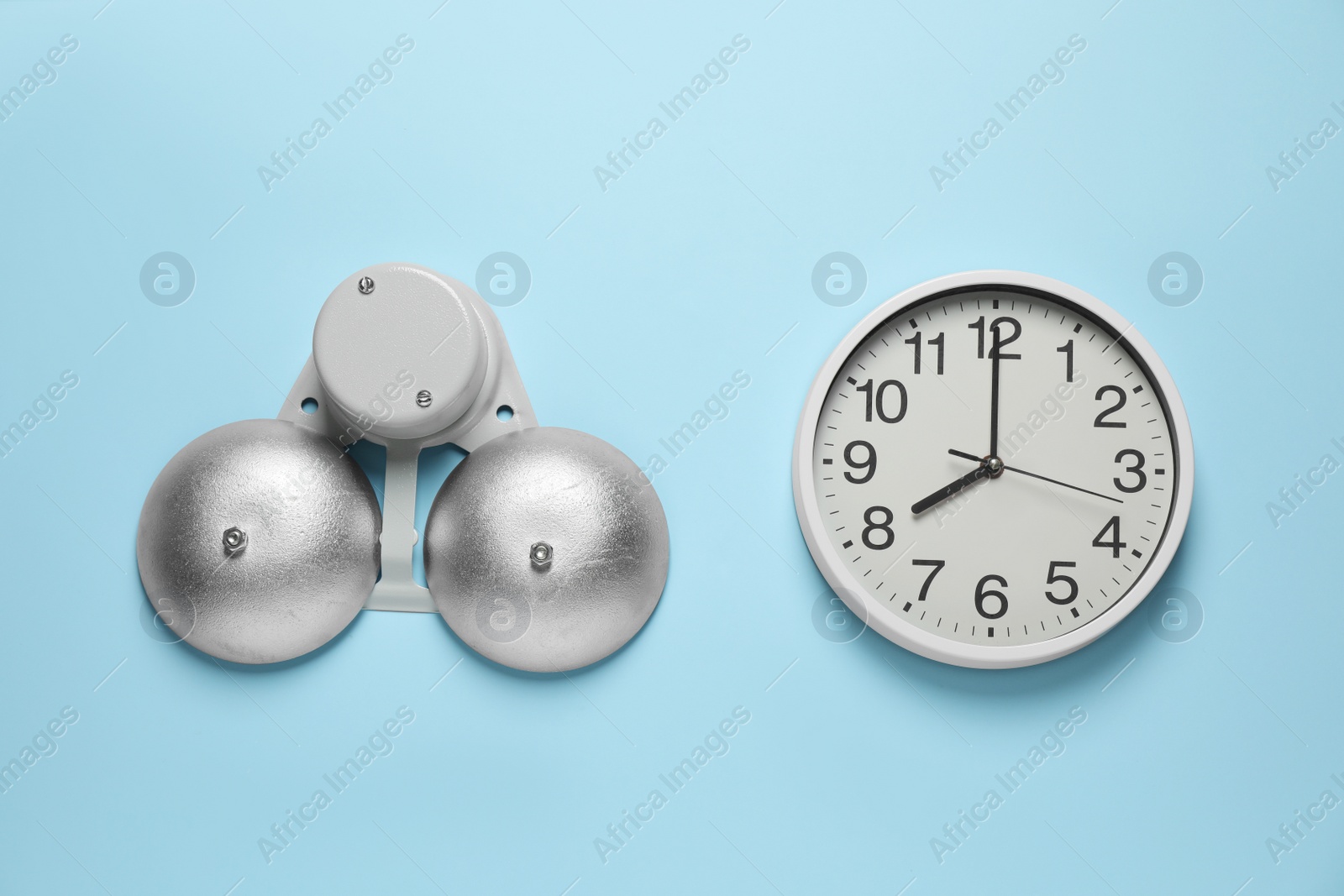 Photo of Modern electrical school bell and clock on light blue wall