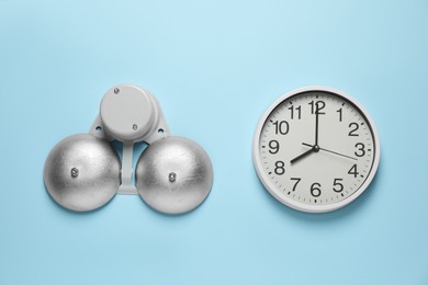 Photo of Modern electrical school bell and clock on light blue wall