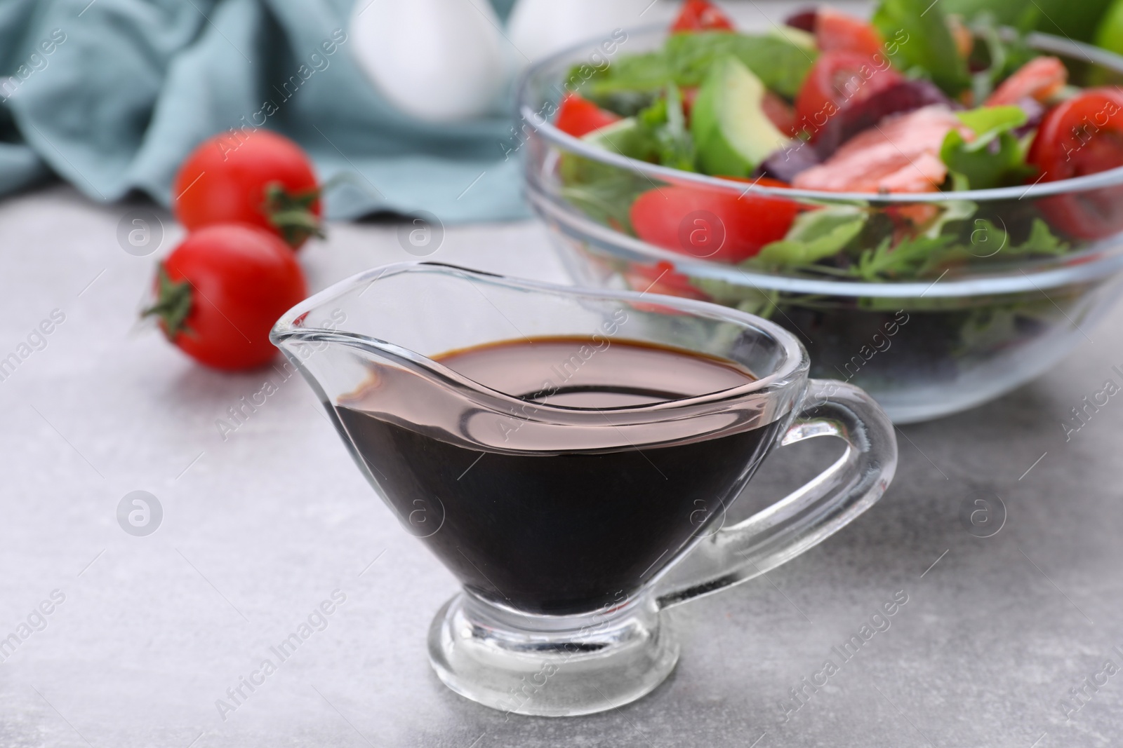 Photo of Soy sauce and vegetable salad on grey table, selective focus