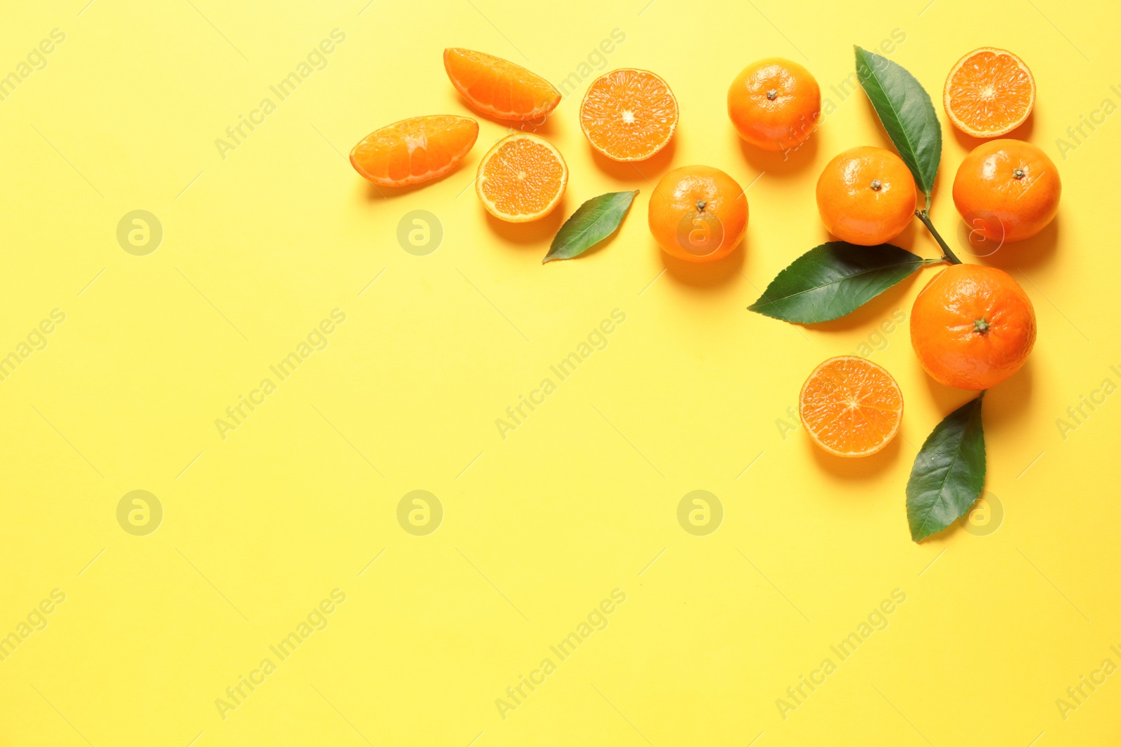 Photo of Fresh tangerines and leaves on color background, flat lay with space for text. Citrus fruits