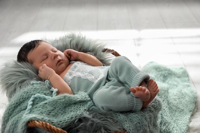 Photo of Cute newborn baby sleeping in wicker basket