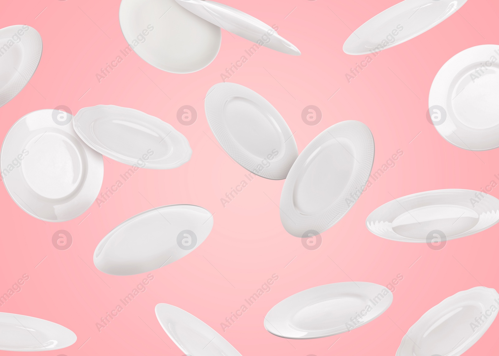 Image of Many white plates falling on pastel pink background