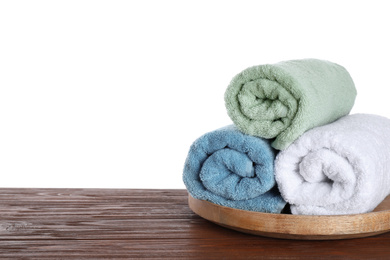 Photo of Fresh towels on wooden table against white background. Space for text