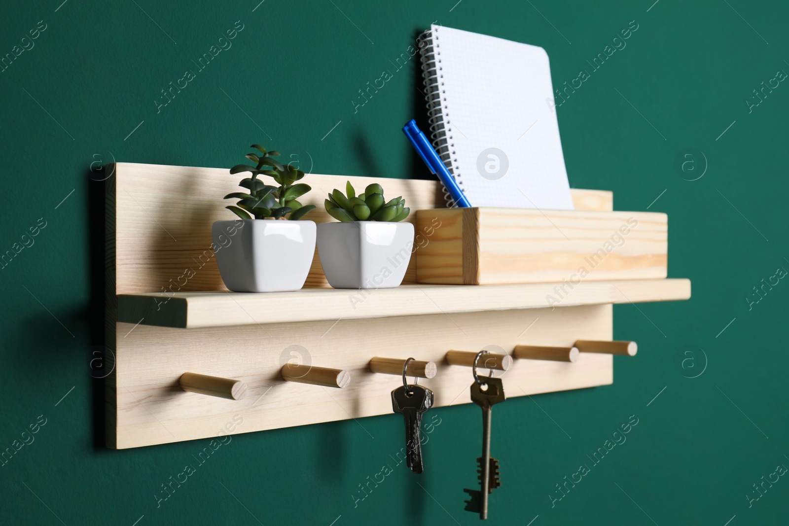 Photo of Wooden hanger for keys on green wall